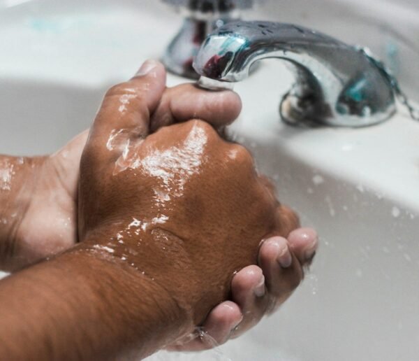 person washing hand on sink